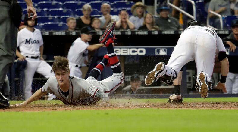 Braves pinch-runner Max Fried scores past Marlins catcher Chad Wallach on a double hit by Ender Inciarte during the 10th inning Sunday, May 5, 2019, in Miami. The Braves won, 3-1, in 10 innings.