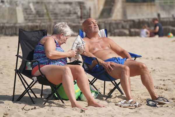 People enjoy the hot weather at Cullercoats Beach in North Shields, England, Friday, June 20, 2025. (Owen Humphreys/PA via AP)