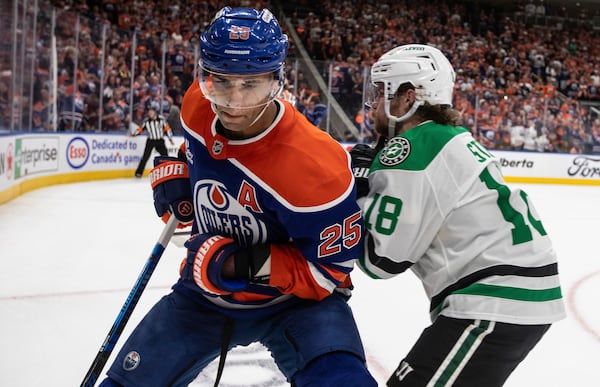 Dallas Stars' Sam Steel (18) and Edmonton Oilers' Darnell Nurse (25) battle in the corner during the third period in Game 4 of the Western Conference finals in the NHL hockey Stanley Cup playoffs in Edmonton, Alberta, Tuesday, May 27, 2025. (Jason Franson/The Canadian Press via AP)