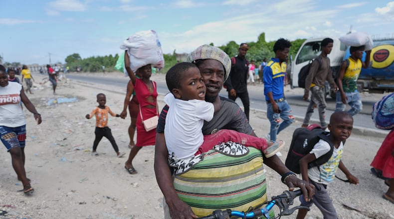 Residents flee their homes to escape clashes between armed gangs in Port-au-Prince, Haiti, Monday, May 11, 2026. (AP Photo/Odelyn Joseph)