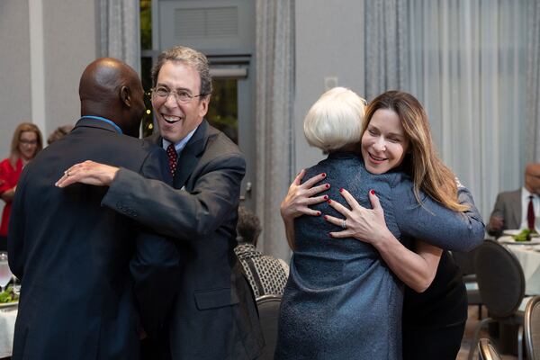 Clark Howard (left) and his wife, Lane, hugging friends at the Atlanta Press Club Hall of Fame ceremony, which inducted Howard on Oct. 28. Courtesy of Krys Alex