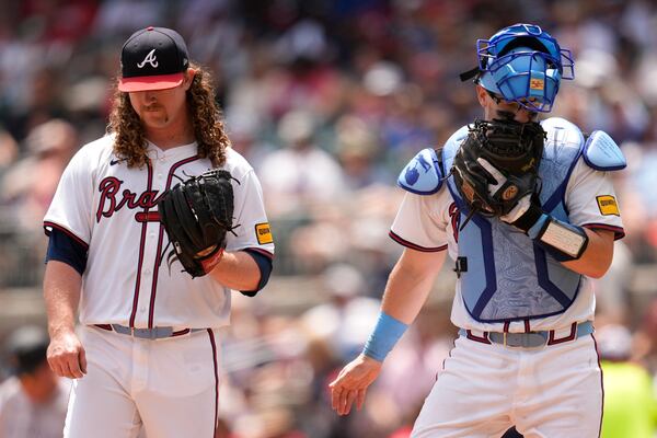 Braves pitcher Grant Holmes (left) talks to catcher Sean Murphy during the sixth inning of Sunday's loss to the Rockies.