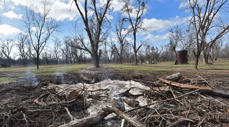 Smoke comes up from burned pecan trees at Justin Jones’ farm in 2019, following damage left by Hurricane Michael in 2018. The U.S. Department of Agriculture announced a new avenue for $800 million in disaster aid aimed at Georgia pecan growers and certain other farmers in a three-state region. But when and how much will be distributed in Georgia is unclear. HYOSUB SHIN / HSHIN@AJC.COM