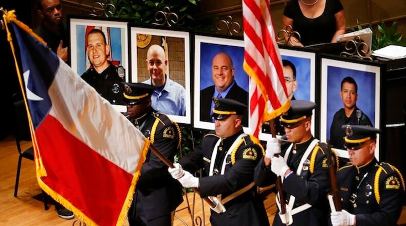 The Dallas Police color guard presents the colors before the photos of five fallen officers being remembered during an interfaith memorial service at the Morton H. Meyerson Symphony Center in Dallas, Tuesday, July 12, 2016. Four Dallas police officers and one Dallas Area Rapid Transit (DART) officer were gunned down last week in downtown Dallas at a protest rally. The victims are depicted, from left, Dallas PD officer Michael Krol, DART officer Brent Thompson, Dallas police Sr. Cpl. Lorne Ahrens, Dallas police Sgt. Michael Smith, and Dallas police Officer Patrick Zamarripa. (Tom Fox/The Dallas Morning News via AP)