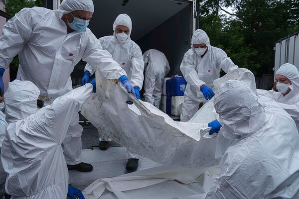 Ukrainian servicemen carry a body of their comrade repatriated from Russia, at the morgue in Kyiv, Ukraine, on Thursday, June 26, 2025. (AP Photo/Evgeniy Maloletka)