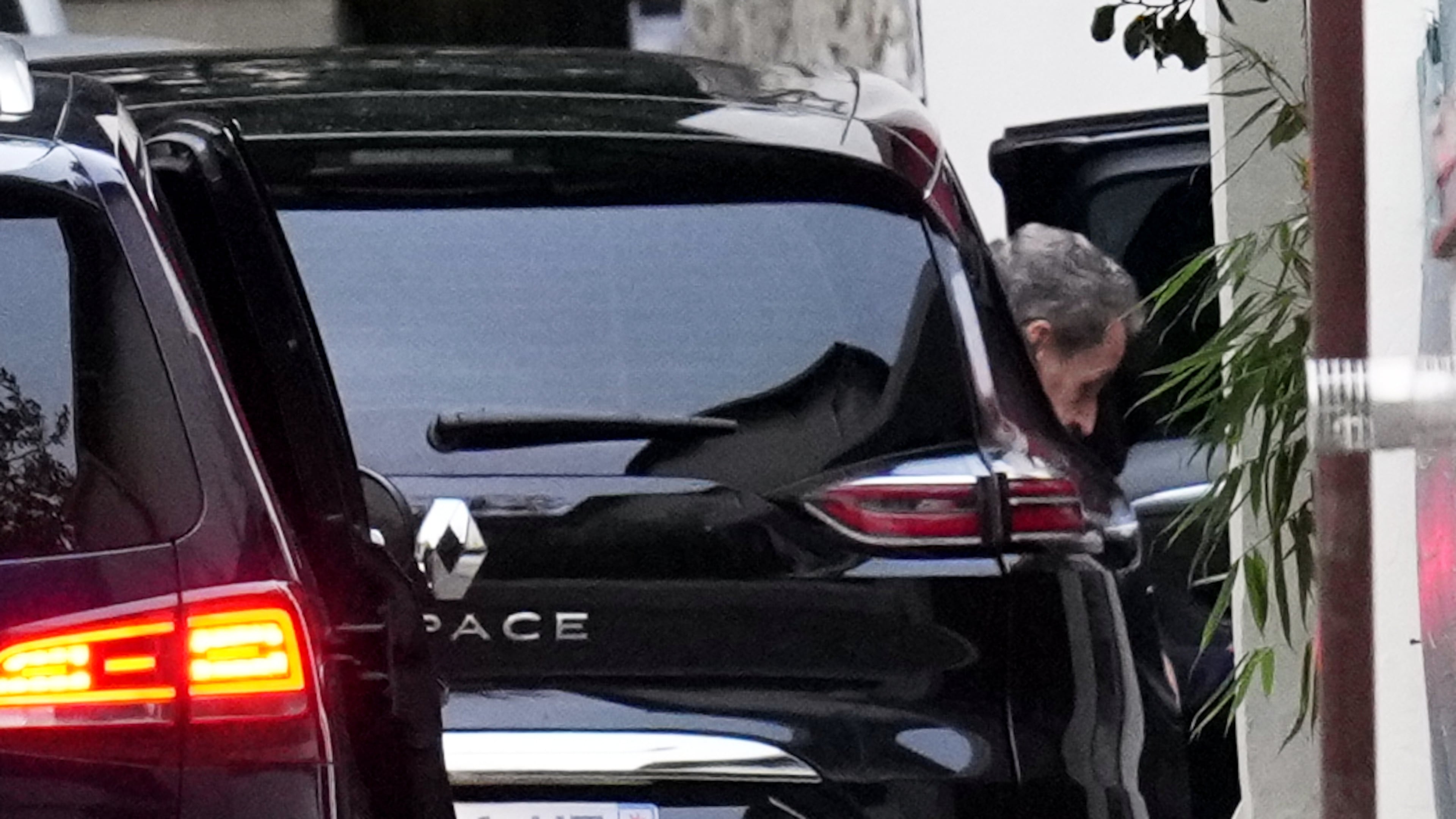 Former French President Nicolas Sarkozy leaves his car as he arrives at his home after being released from prison, Monday, Nov. 10, 2025 in Paris. (AP Photo/Christophe Ena)