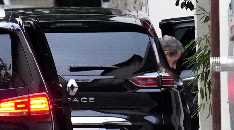 Former French President Nicolas Sarkozy leaves his car as he arrives at his home after being released from prison, Monday, Nov. 10, 2025 in Paris. (AP Photo/Christophe Ena)