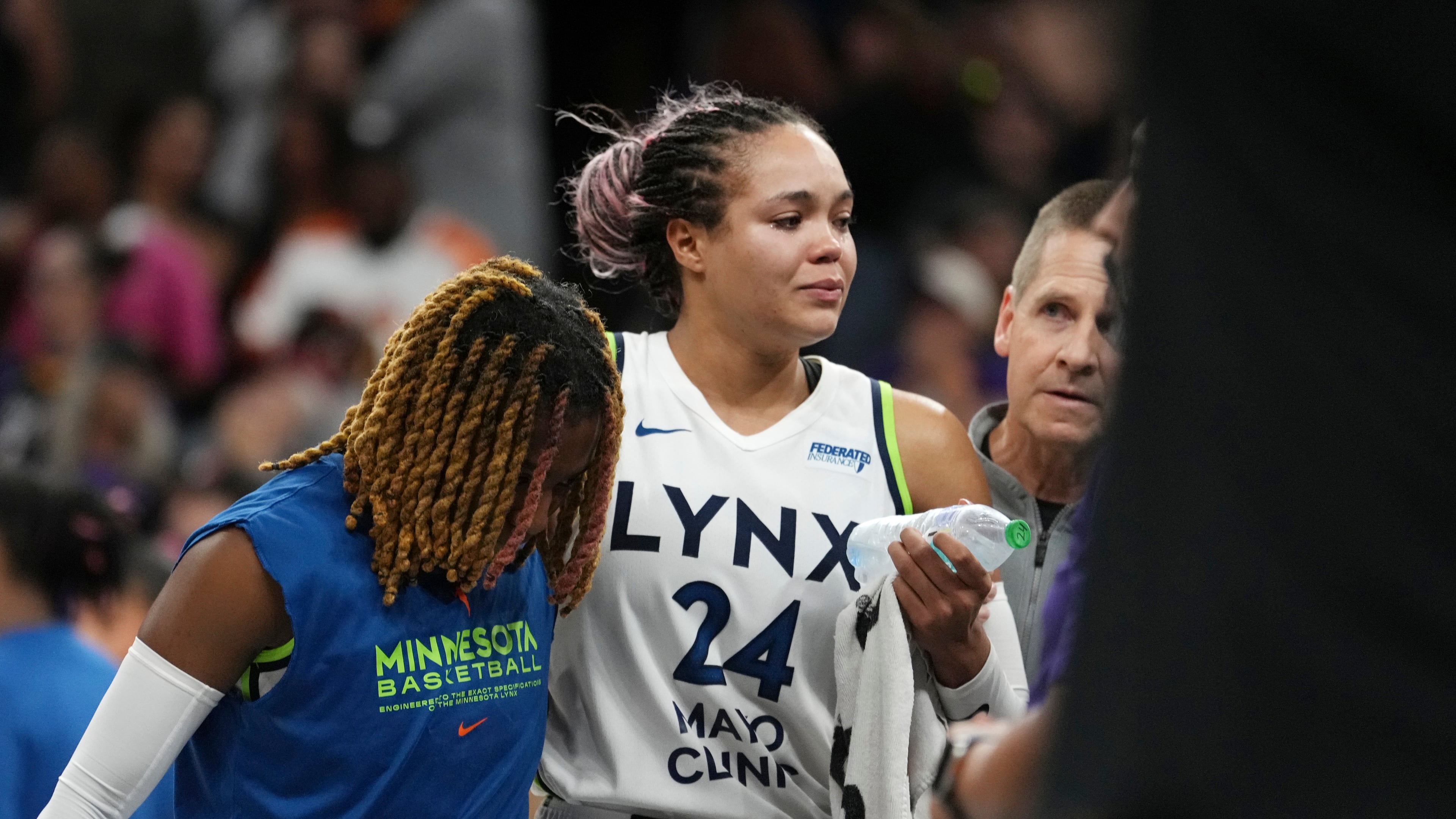 An injured Minnesota Lynx forward Napheesa Collier is helped off the court during the second half of Game 3 of a WNBA basketball playoff semifinals series game against the Phoenix Mercury Friday, Sept. 26, 2025, in Phoenix. (AP Photo/Ross D. Franklin)