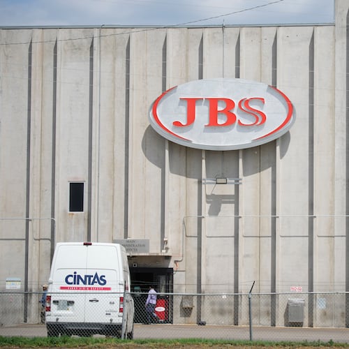 FILE - Employees walk in front of the entrance to the JBS meat processing plant, July 23, 2021, in Greeley, Colo. (AP Photo/David Zalubowski, File)