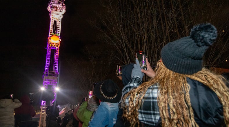 Kywanda Hammothe, right, captures the drop during the count down to 2025.  The Peach Drop returns to Underground Atlanta with a free concert including Big Boi as the headliner on Tuesday, Dec 31, 2024.  (Jenni Girtman for The Atlanta Journal-Constitution)