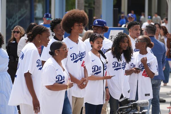People gather at Dodger Stadium to commemorate Jackie Robinson Day before a baseball game against the Colorado Rockies Tuesday, April 15, 2025, in Los Angeles. (AP Photo/Damian Dovarganes)