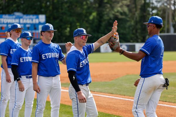 Etowah outfielder Trevor Condon (center) high-fives a teammate before the game against Harrison High School during the High School Baseball Playoffs at Etowah High School in Woodstock on April 24, 2026. (Arvin Temkar/AJC)