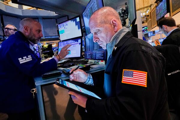 Specialist Meric Greenbaum, left and trader Michael Urkonis, center, work on the floor of the New York Stock Exchange, Wednesday, April 16, 2025. (AP Photo/Richard Drew)