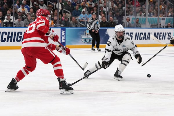 Boston University's Sascha Boumedienne, left, pass around Western Michigan's Wyatt Schingoethe (18) during the first period in the championship game of the NCAA Frozen Four men's college hockey tournament, Saturday, April 12, 2025, in St. Louis (AP Photo/Jeff Roberson)