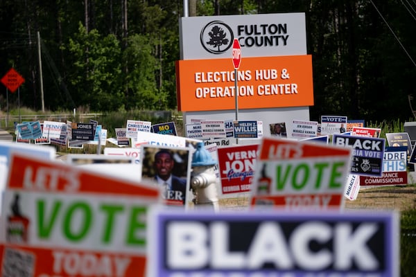Campaign signs line the road outside of the Fulton County Elections Hub and Operation Center on Tuesday. (Ben Gray for the AJC)