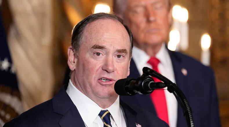FILE - Secretary of the Navy John Phelan speaks, as President Donald Trump listens, at Trump's Mar-a-Lago club, Dec. 22, 2025, in Palm Beach, Fla. (AP Photo/Alex Brandon, file)