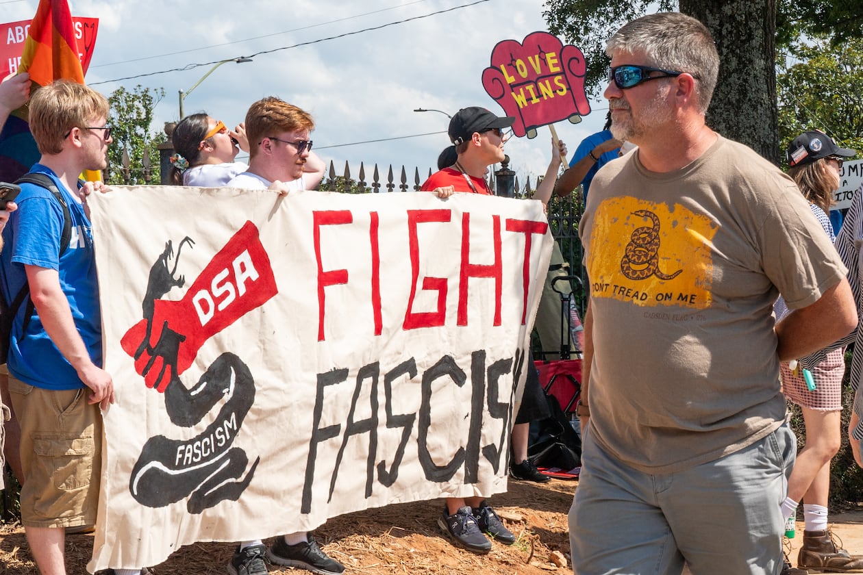 Trump rally attendees walk past a Democratic Socialists of America protest outside the Georgia State Convocation Center in Atlanta on Saturday, August 3, 2024. (Seeger Gray/AJC)