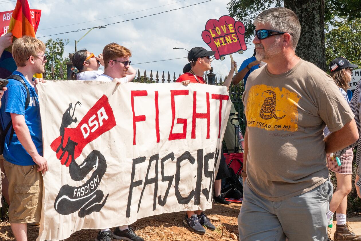 People walk past a Democratic Socialists of America protest outside the Georgia State Convocation Center in Atlanta last month. (Seeger Gray/AJC)