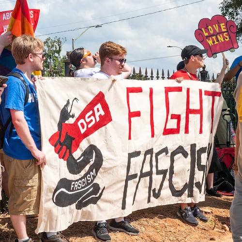 Trump rally attendees walk past a Democratic Socialists of America protest outside the Georgia State Convocation Center in Atlanta on Saturday, August 3, 2024. (Seeger Gray/AJC)