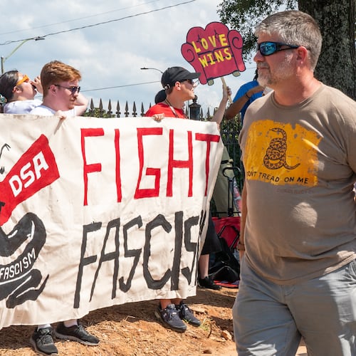 People walk past a Democratic Socialists of America protest outside the Georgia State Convocation Center in Atlanta last month. (Seeger Gray/AJC)