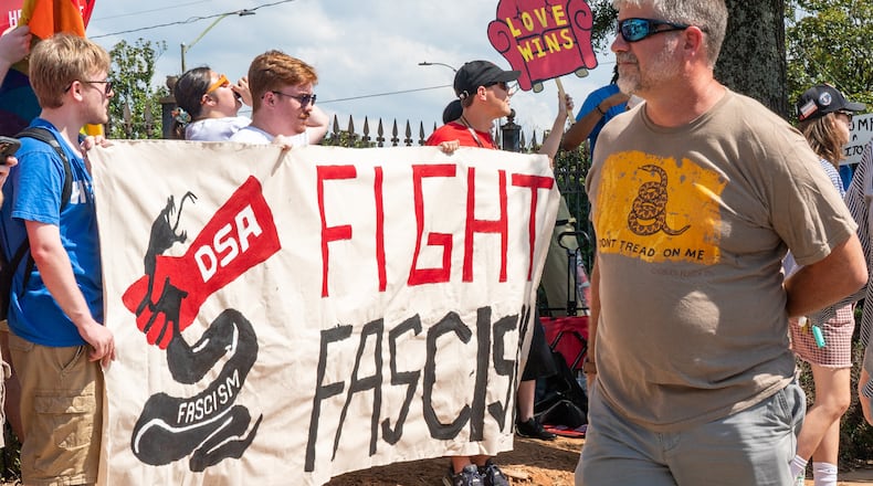 Trump rally attendees walk past a Democratic Socialists of America protest outside the Georgia State Convocation Center in Atlanta on Saturday, August 3, 2024. (Seeger Gray/AJC)