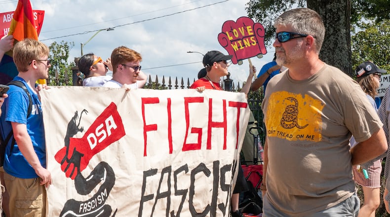 People walk past a Democratic Socialists of America protest outside the Georgia State Convocation Center in Atlanta last month. (Seeger Gray/AJC)