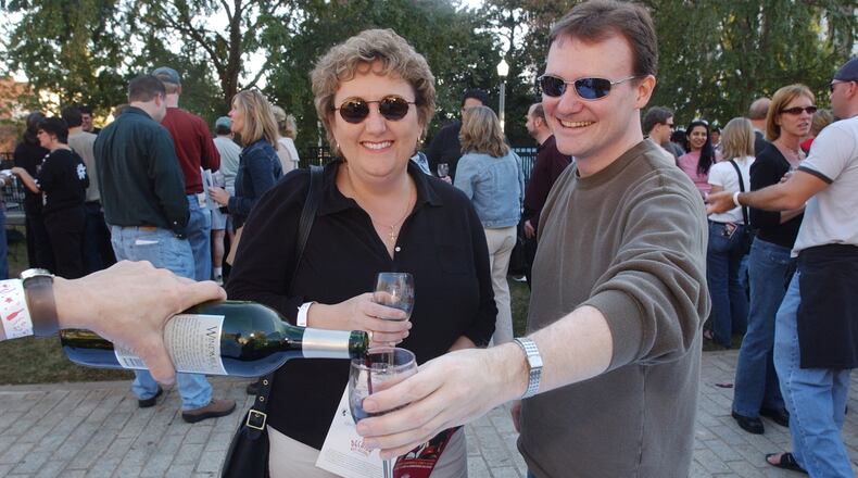 Leona Davis, left, of Atlanta, and Carl Black, right, of DeKalb County, enjoy the day as Black tries a sample of a California merlot from the Grape Expectations table Saturday, November 6, 2004 at the 3rd Annual Decatur Wine Festival on the square in downtown Decatur.