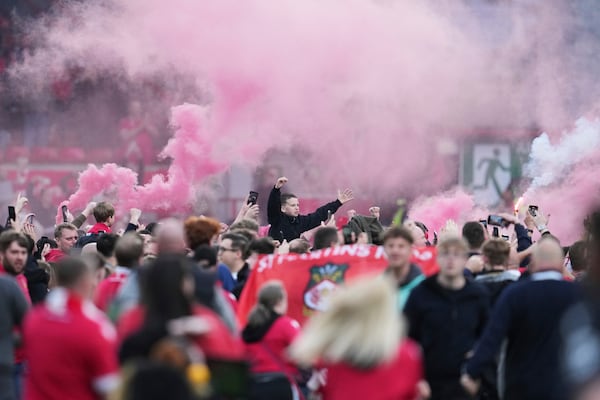 Wrexham players celebrate with fans as they win the English League One soccer match between Wrexham and Charlton Athletic at the Racecourse ground in Wrexham, Wales, Saturday, April 26, 2025. (AP Photo/Jon Super)