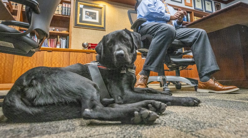 Chief Judge Ural Glanville sits in his Fulton County courtroom office with his service dog, Jack, on Tuesday, Sept. 26, 2023.  (Steve Schaefer/steve.schaefer@ajc.com)