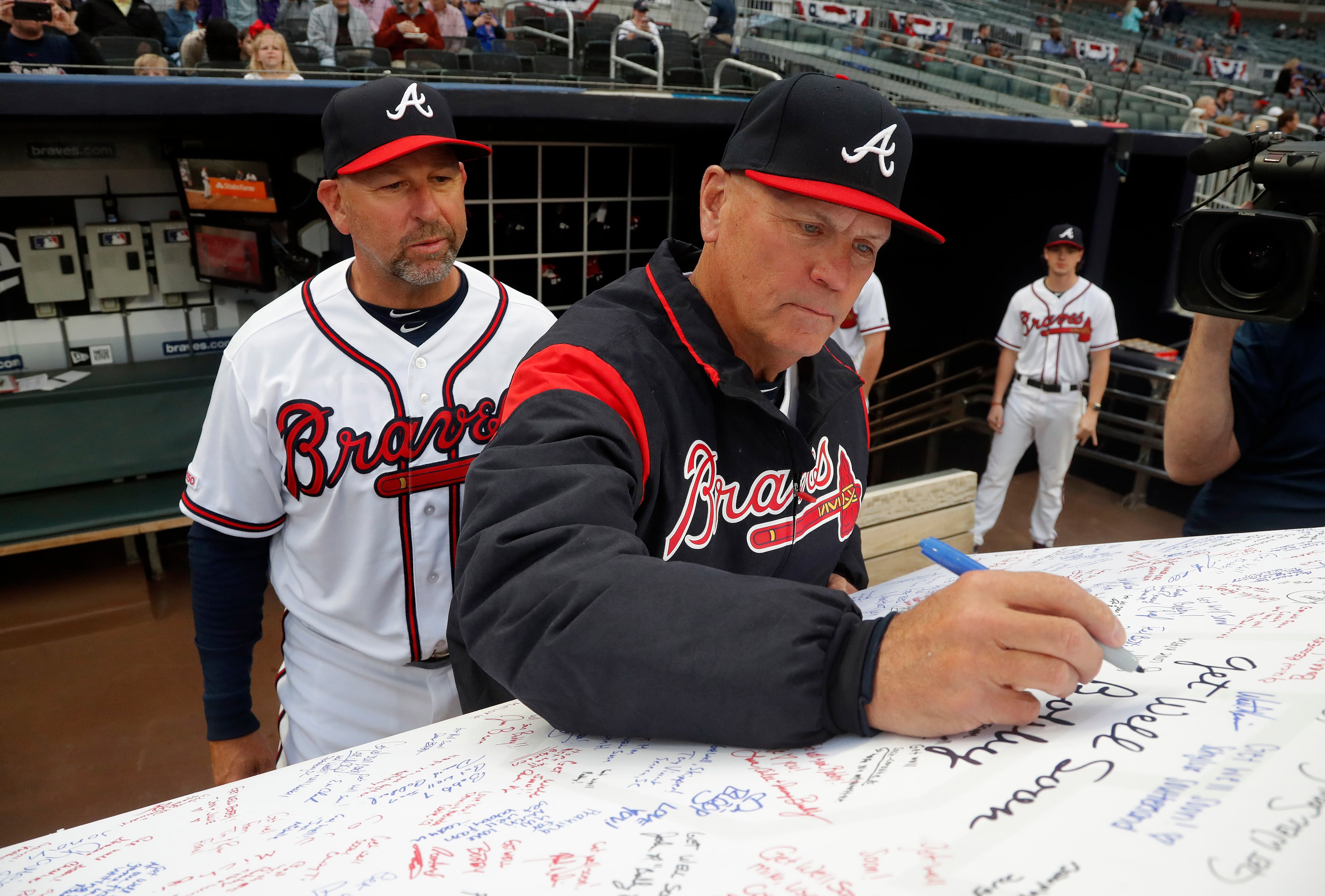 In this 2019 file photo, Braves manager Brian Snitker signs a get well card for mentor Bobby Cox after the latter suffered a stroke. Bench coach Walt Weiss waited his turn.