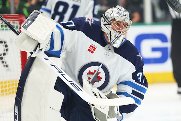 Winnipeg Jets goaltender Connor Hellebuyck recovers from making a save on a shot from the Dallas Stars in the first period of Game 6 of a second-round NHL hockey playoff series in Dallas, Saturday, May 17, 2025. (AP Photo/Gareth Patterson)