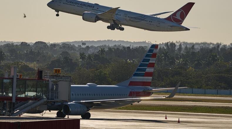 A Turkish Airlines plane takes off alongside an American Airlines plane at Jose Marti International Airport in Havana, Cuba, Monday, Feb. 9, 2026. (AP Photo/Ramon Espinosa)