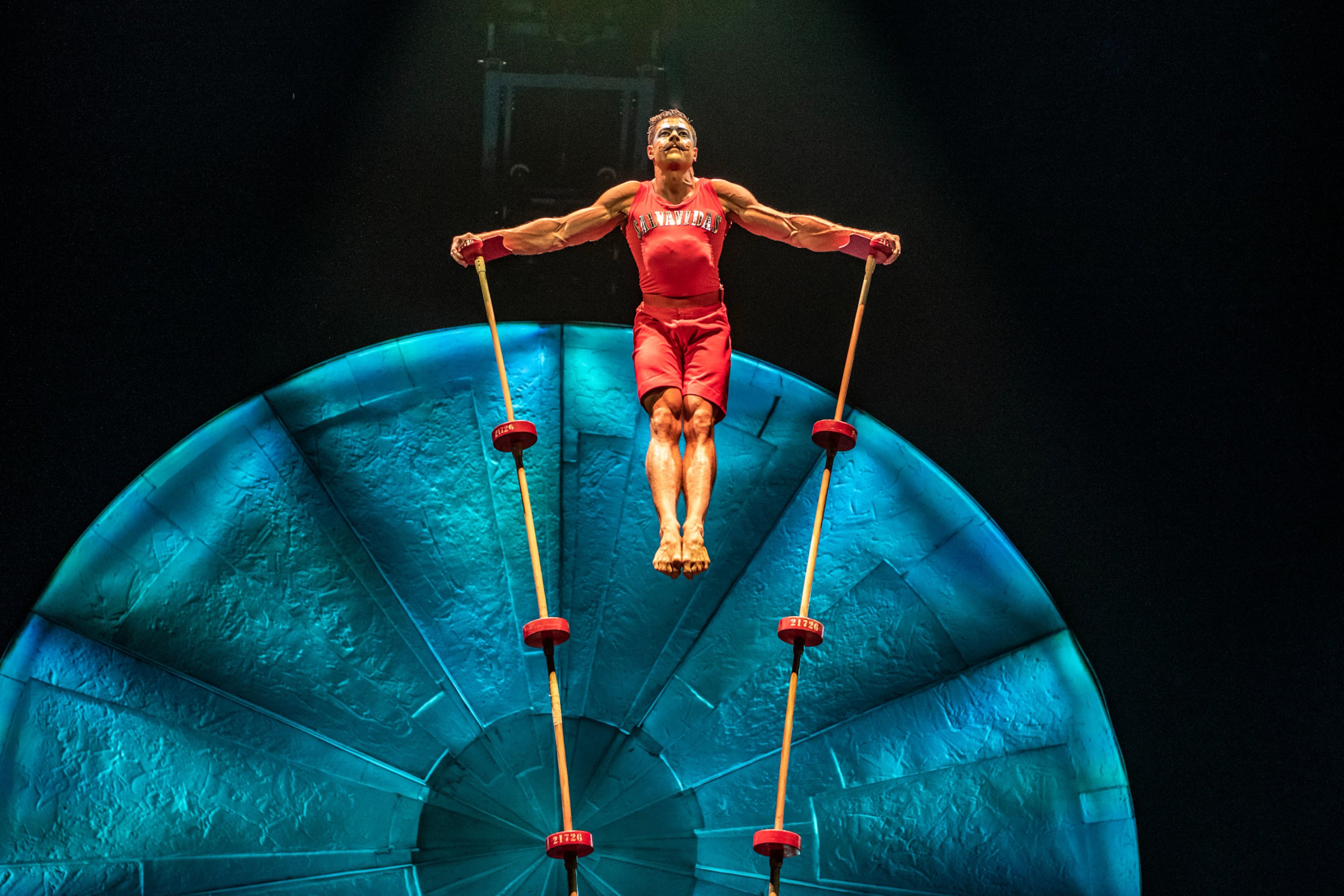 A Cirque du Soleil performer in “Luzia” balances high atop poles, demonstrating awe-inspiring strength and agility. (Courtesy of Matt Beard and Anne Colliard)