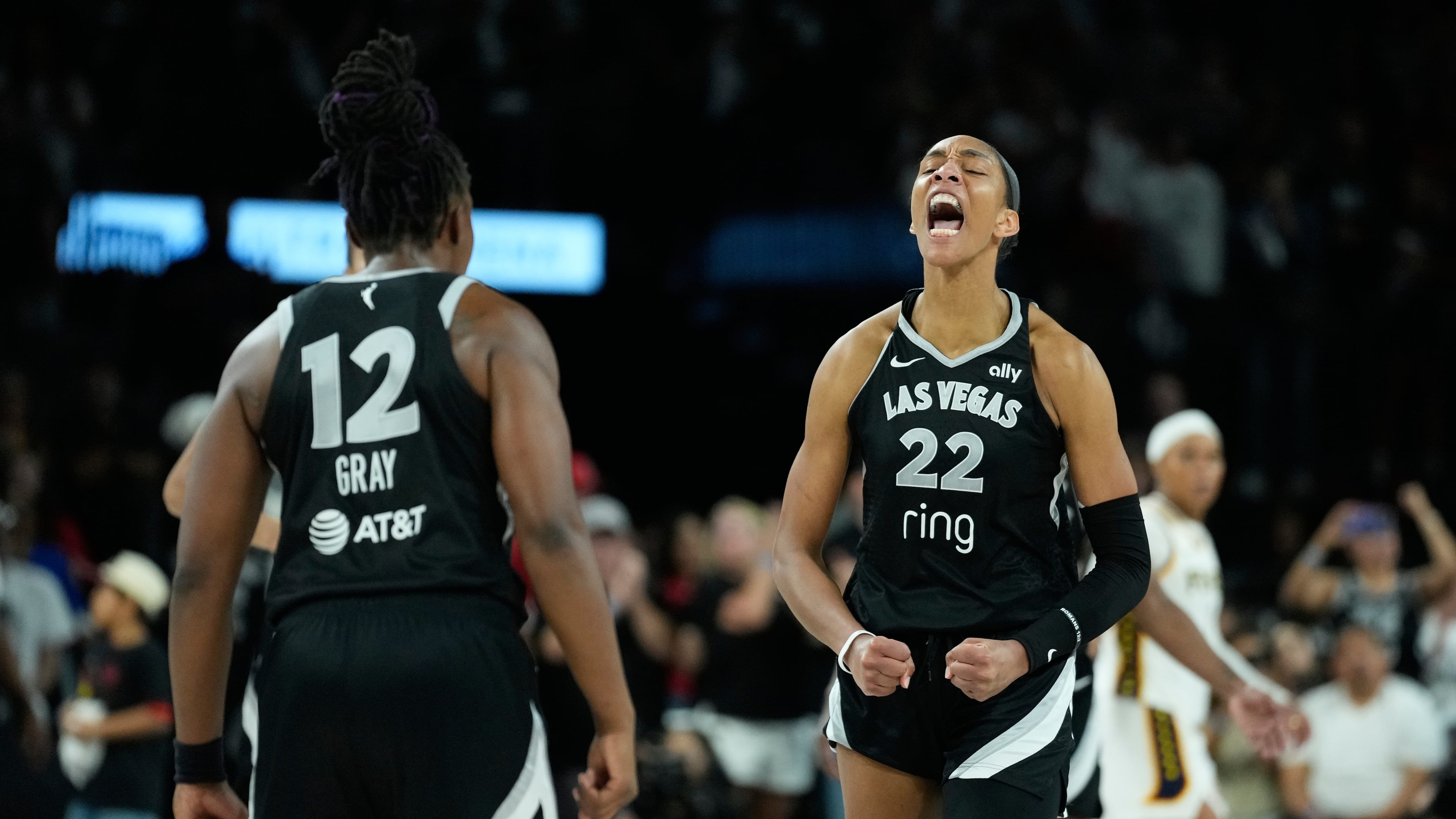 Las Vegas Aces center A'ja Wilson (22) and Las Vegas Aces guard Chelsea Gray (12) celebrate after a play against the Indiana Fever during overtime in Game 5 of a WNBA basketball playoff semifinals series Tuesday, Sept. 30, 2025, in Las Vegas. (AP Photo/John Locher)