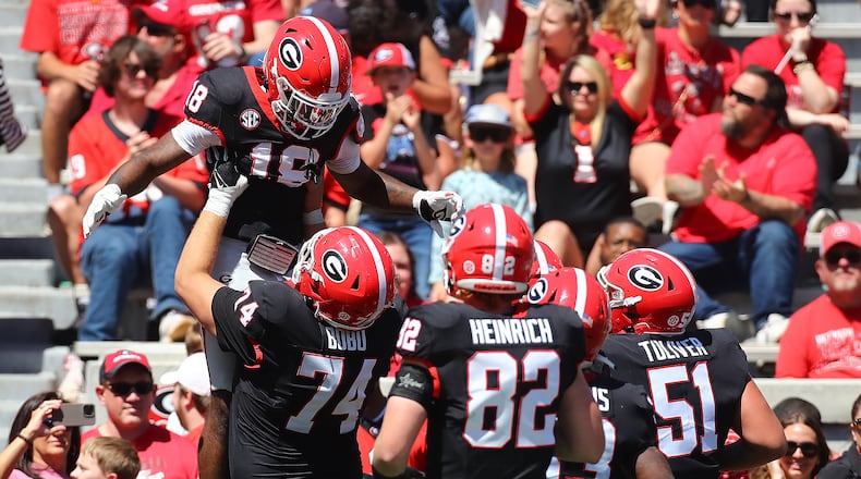 041324 Athens: Drew Bobo (74) hoists receiver Sacovie White in the air after White scored a touchdown to give the black team a 17-13 lead during the G-Day game on Saturday, April 13, 2024. Curtis Compton for the Atlanta Journal Constitution