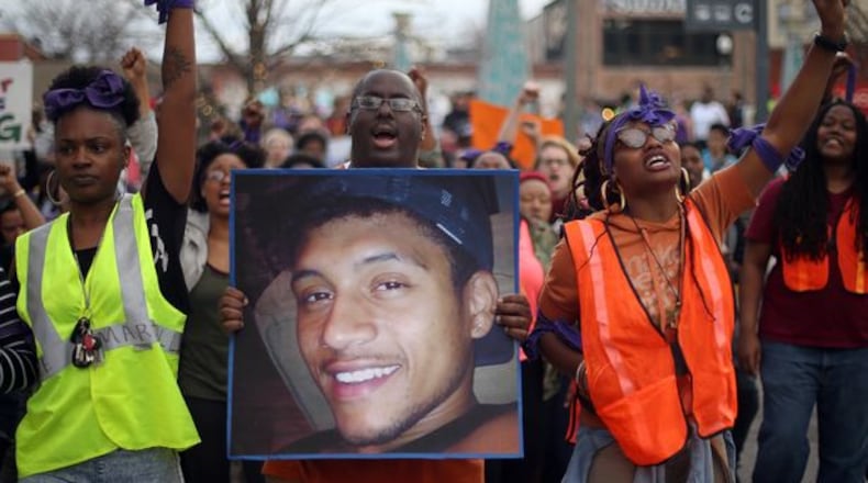 Protesters, including Brandan Marshall holding a photo of Anthony Hill, take to the streets of downtown Decatur to protest Hill’s shooting death on March 9, 2015. Hill was killed by a DeKalb police officer, who later was indicted in the shooting. BEN GRAY / BGRAY@AJC.COM