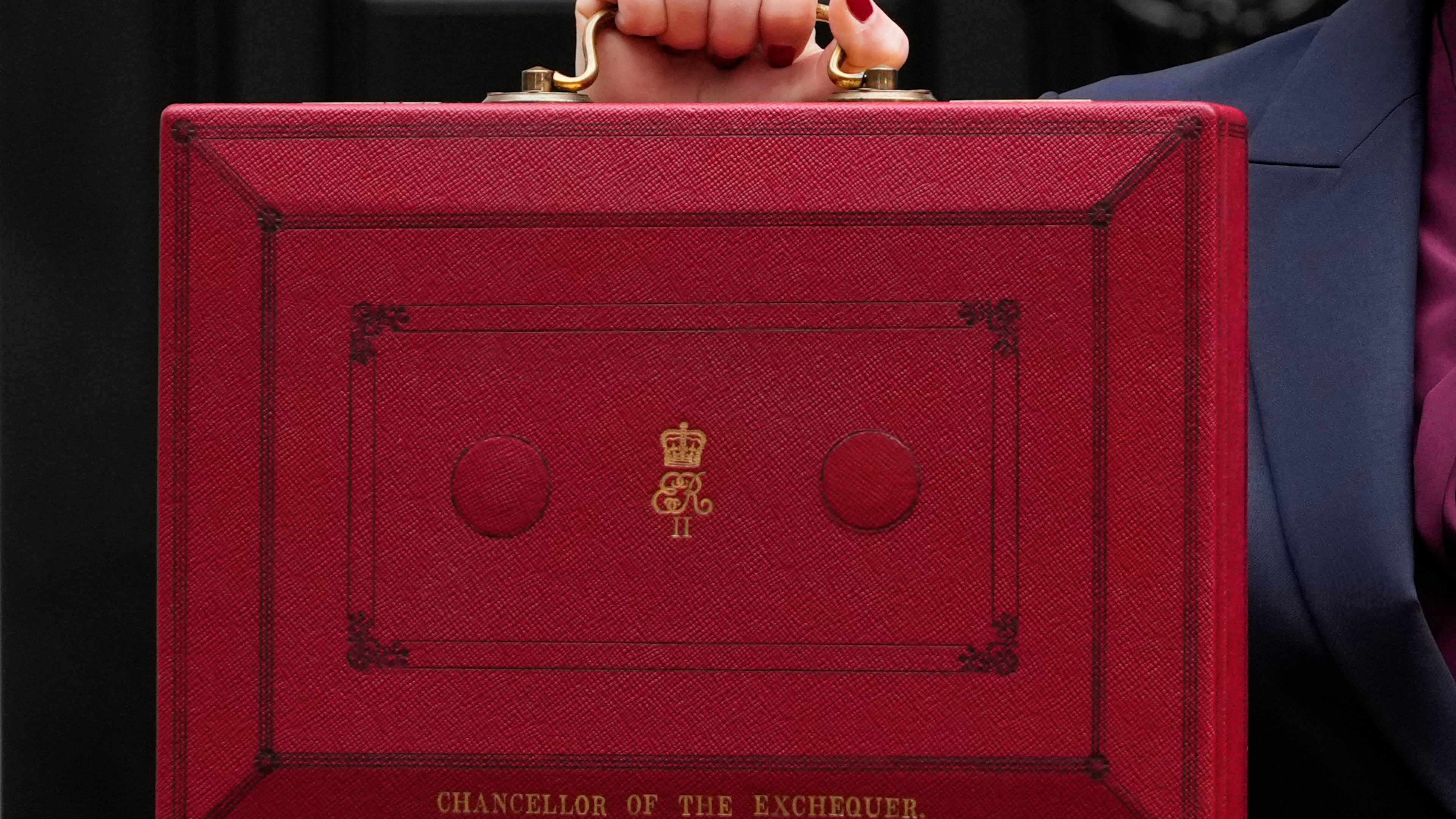 FILE - Britain's Chancellor of the Exchequer, Rachel Reeves, holds up the traditional red ministerial box containing her budget speech, as she poses for the media outside No 11 Downing Street, before departing to the House of Commons to deliver the budget in London, Wednesday, Oct. 30, 2024. (AP Photo/Kirsty Wigglesworth, File)