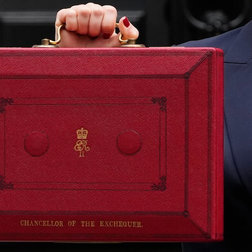 FILE - Britain's Chancellor of the Exchequer, Rachel Reeves, holds up the traditional red ministerial box containing her budget speech, as she poses for the media outside No 11 Downing Street, before departing to the House of Commons to deliver the budget in London, Wednesday, Oct. 30, 2024. (AP Photo/Kirsty Wigglesworth, File)