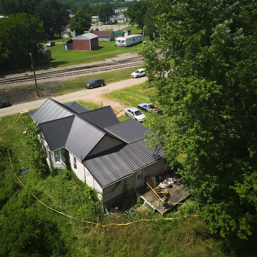 Police tape surrounds a home where authorities say they removed 16 children and arrested four adults in Hamden, Ohio, Wednesday, July 1, 2026. (AP Photo/Carolyn Kaster)