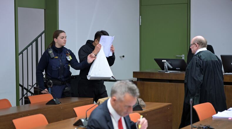 The defendant covers his face as he arrives for a trial against a network of mostly Chinese men, organized in chat groups to advise one another on how to drug and rape mostly Chinese women, in Munich, Germany, Feb. 2, 2026. (Malin Wunderlich/dpa via AP)