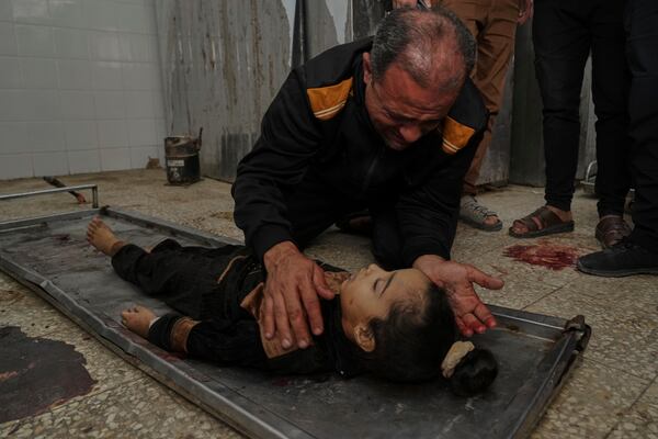 EDS NOTE: GRAPHIC CONTENT - Ahmed Dalloul mourns over the body of his 4-year-old daughter, Siwar, who was killed in an Israeli airstrike, at the morgue of Al-Aqsa Hospital in Deir al-Balah, central Gaza Strip, Thursday, April 17, 2025. (AP Photo/Abdel Kareem Hana)