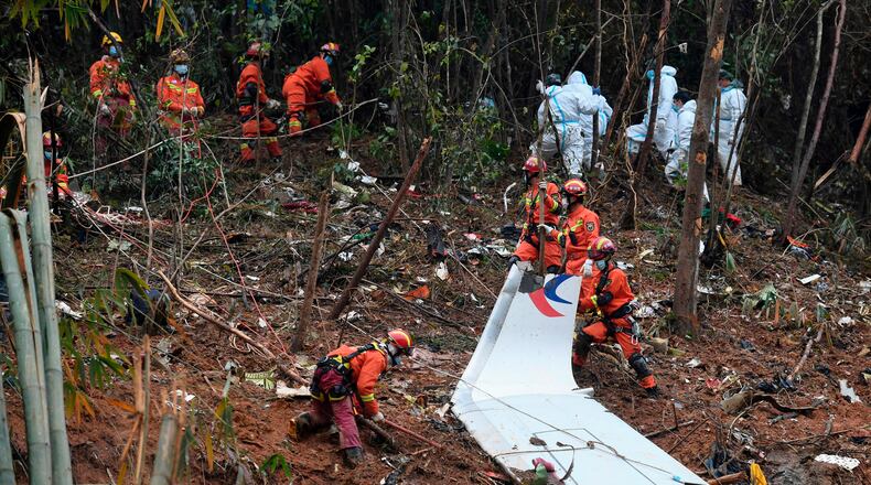FILE - In this photo released by Xinhua News Agency, search and rescue workers search through debris at the China Eastern flight crash site in Tengxian County in southern China's Guangxi Zhuang Autonomous Region on March 24, 2022. (Lu Boan/Xinhua via AP, File)