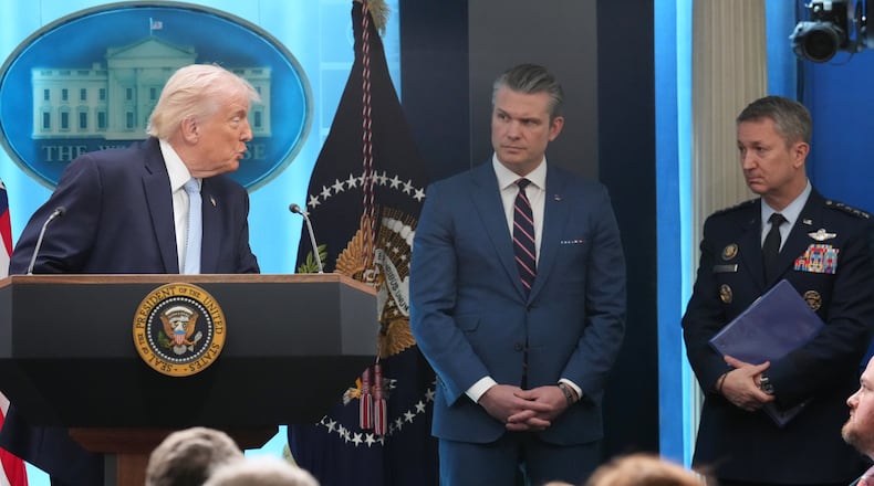 President Donald Trump looks to Defense Secretary Pete Hegseth and Chairman of the Joint Chiefs of Staff Gen. Dan Caine as he speaks with reporters during a news conference in the James Brady Press Briefing Room at the White House, Monday, April 6, 2026, in Washington. (AP Photo/Mark Schiefelbein)
