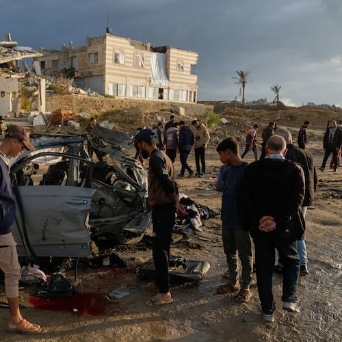 Palestinians looks at a destroyed car following an Israeli strike in Gaza City, Saturday, Dec. 13, 2025. (AP Photo/Jehad Alshrafi)