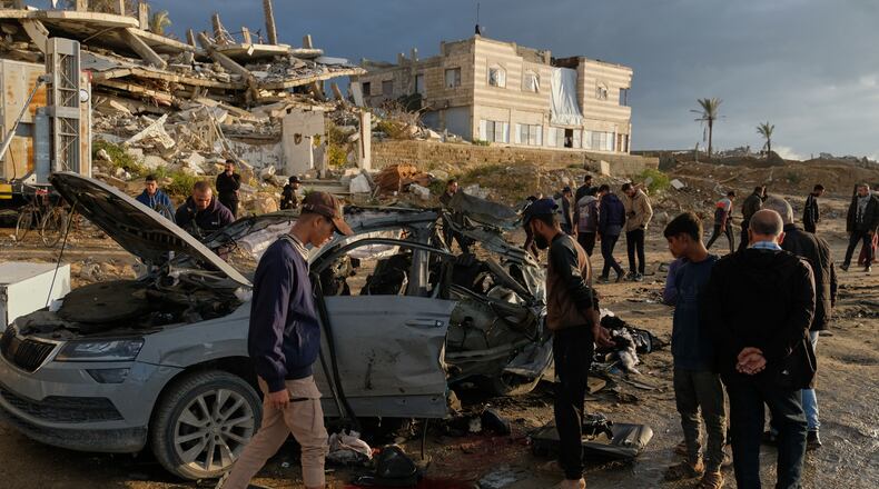 Palestinians looks at a destroyed car following an Israeli strike in Gaza City, Saturday, Dec. 13, 2025. (AP Photo/Jehad Alshrafi)