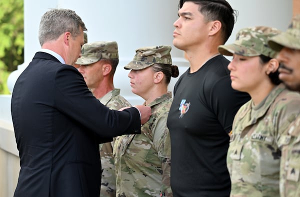 Staff Sgt. Melissa Taylor receives the Meritorious Service Medal from Secretary of the Army Dan Driscoll at Fort Stewart on Thursday, Aug. 6, 2025. During the recent shooting on the base, soldiers immediately leapt into action. (Hyosub Shin/AJC)