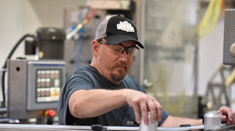 Owner and brewer Dave Sheets operates machinery filling cans with beer at Ironmonger Brewing in Marietta. The recent round of tariffs has raised costs for beverage companies in Georgia. HYOSUB SHIN / HSHIN@AJC.COM