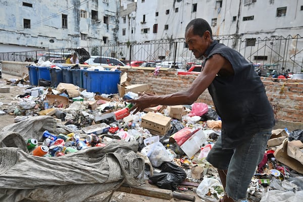 A man culls through garbage collecting aluminium cans for recycling, in Havana, Cuba, Tuesday, July 15, 2025. (AP Photo/Jorge Luis Baños)