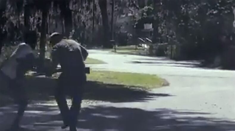 In this image from video posted on Twitter on Tuesday, May 5, 2020, Ahmaud Arbery stumbles and begins falling after being shot as Travis McMichael stands by holding a shotgun in a neighborhood outside Brunswick, Ga., on Feb. 23, 2020.