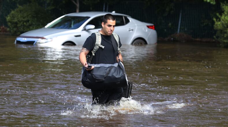 Nestor Monreal walks through flood waters as he evacuates from his apartment due to flood waters from the Little River, as it crests from the rains caused by Hurricane Florence on Tuesday in Spring Lake, North Carolina. Joe Raedle/Getty Images